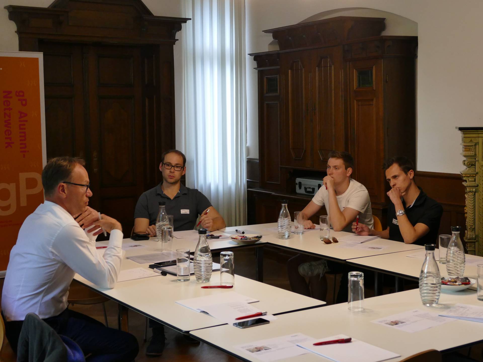 Alumnus Adrian Fischer (l.) im Gespräch mit Studierenden des Netzwerks gP Primus.