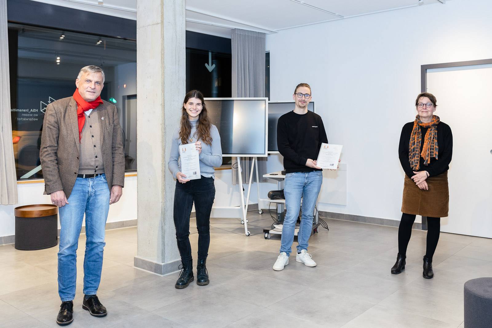 Die Studienergebnisse "" werden an Susanne Flynn, Quartiersmanagerin für die Jakobervorstadt Nord (rechts) und Helmut Jesske, Geschäftsführer des Stadtjugendrings Augsburg (links) überreicht.