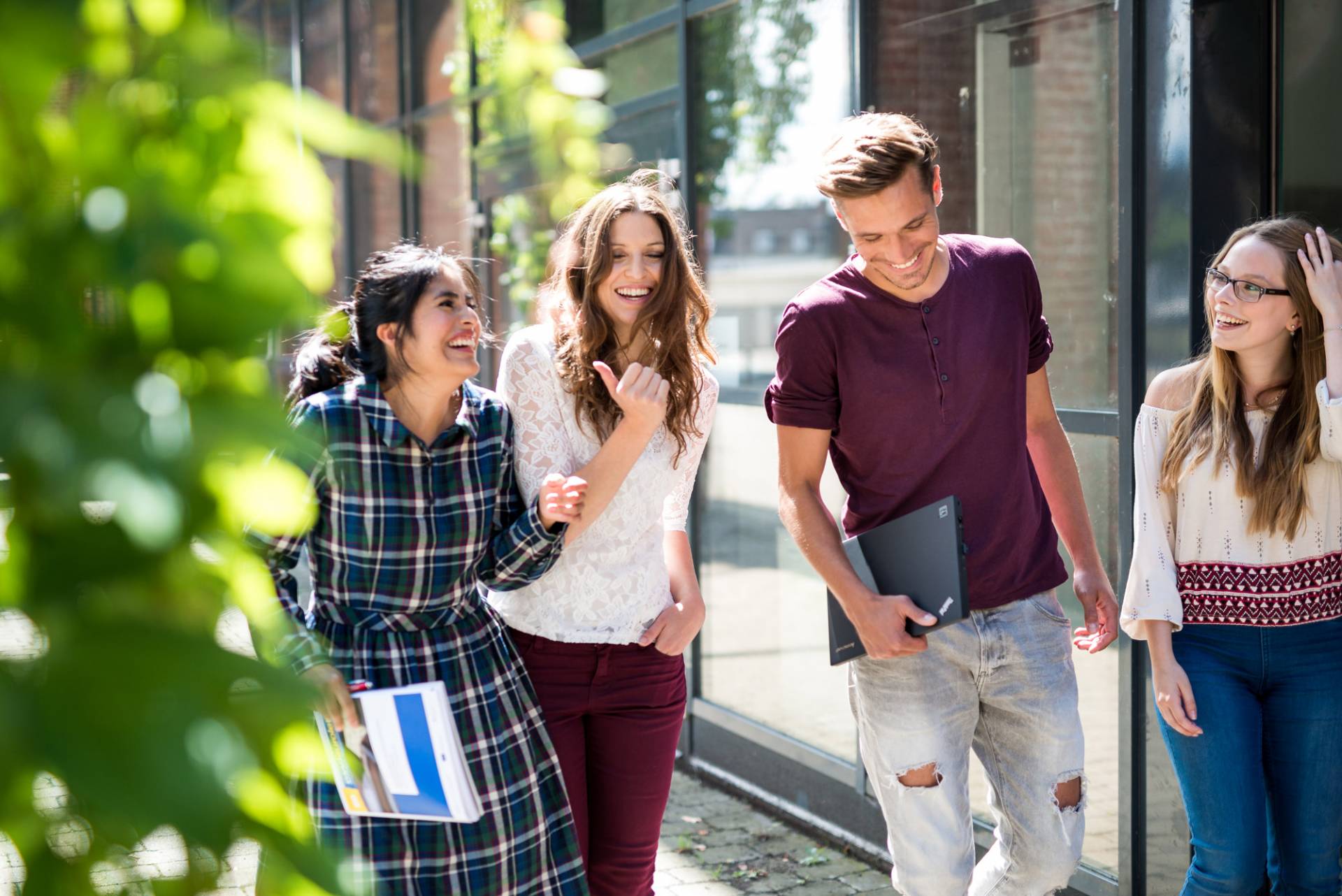 Studierende flanieren gut gelaunt über die Straße