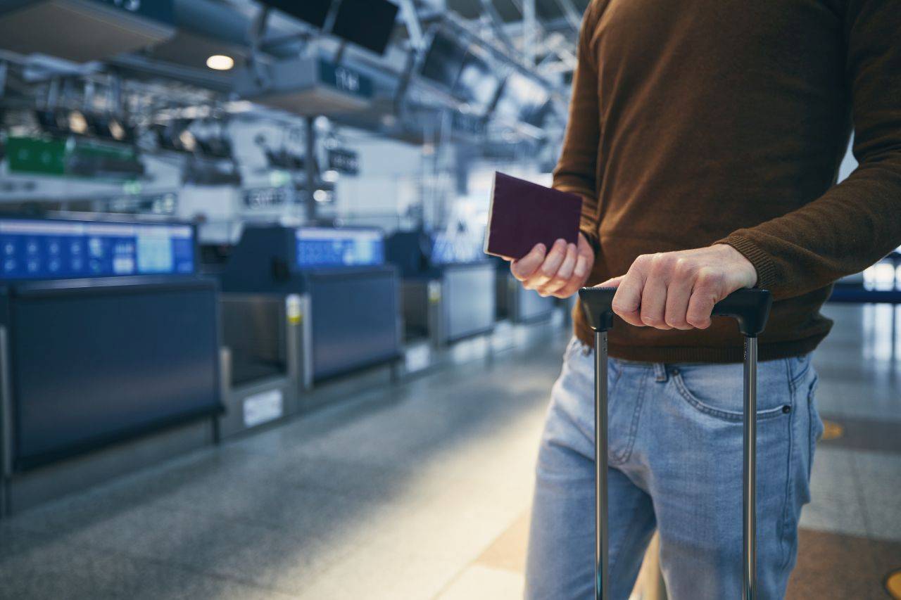 Mann steht am Schalter auf dem Flughafen