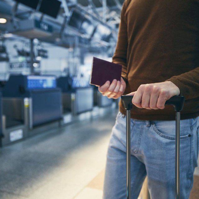 Mann steht am Schalter auf dem Flughafen