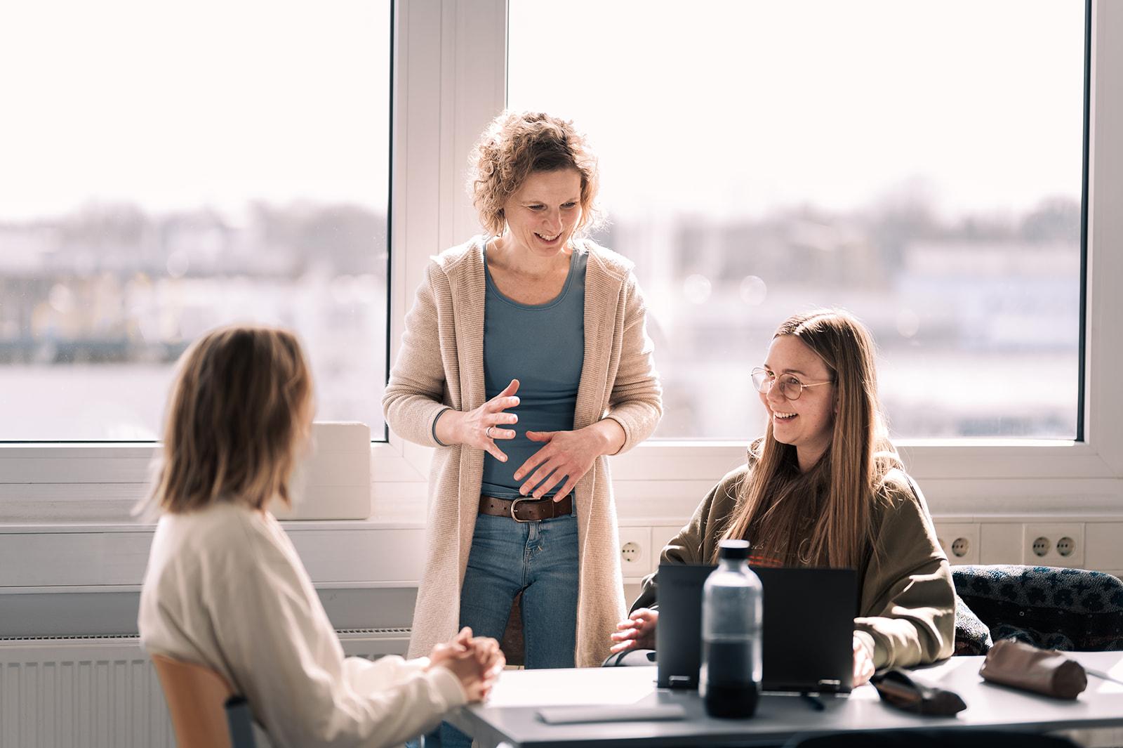 Dozentin mit Studierenden im Dialog