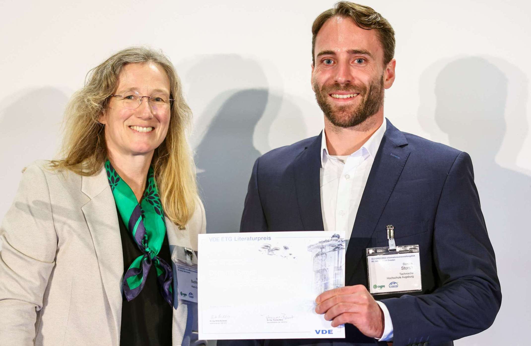 Dominik Storch (rechts) nimmt den Literarturpreis der Energietechnischen Gesellschaft von der ETG- Vorstandsvorsitzende Dr.-Ing. Britta Buchholz entgegen. Foto: Hannibal / VDE  