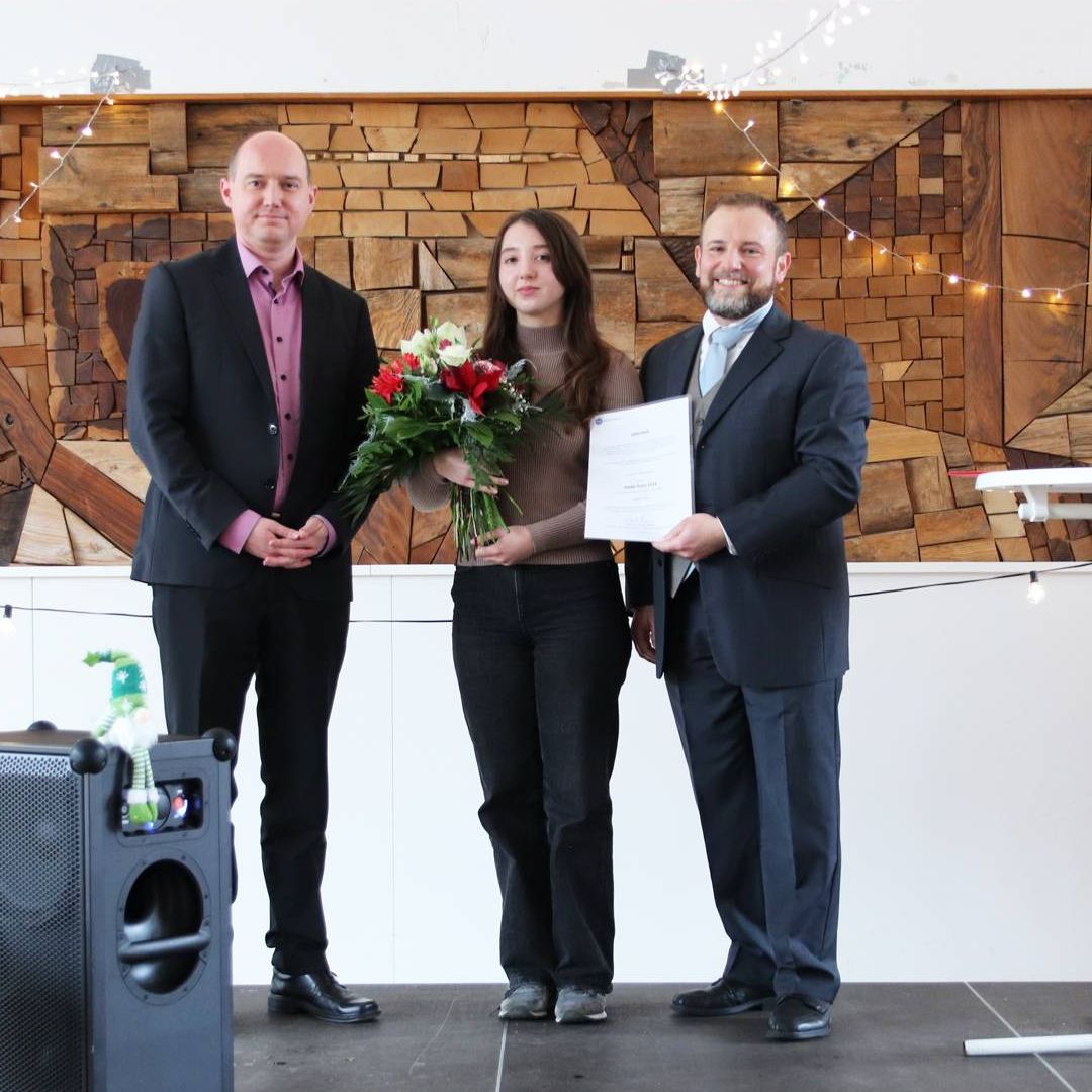 Dominik Maas (links) und Prof. Matthias Kolonko (rechts) überreichten den DAAD-Preis 2024 der THA an Oleksandra Suzik. 