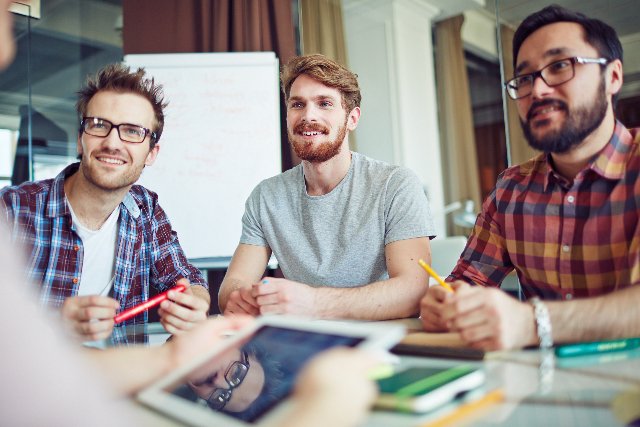 Studierende sitzen am Tisch und nehmen an einem Gespräch teil