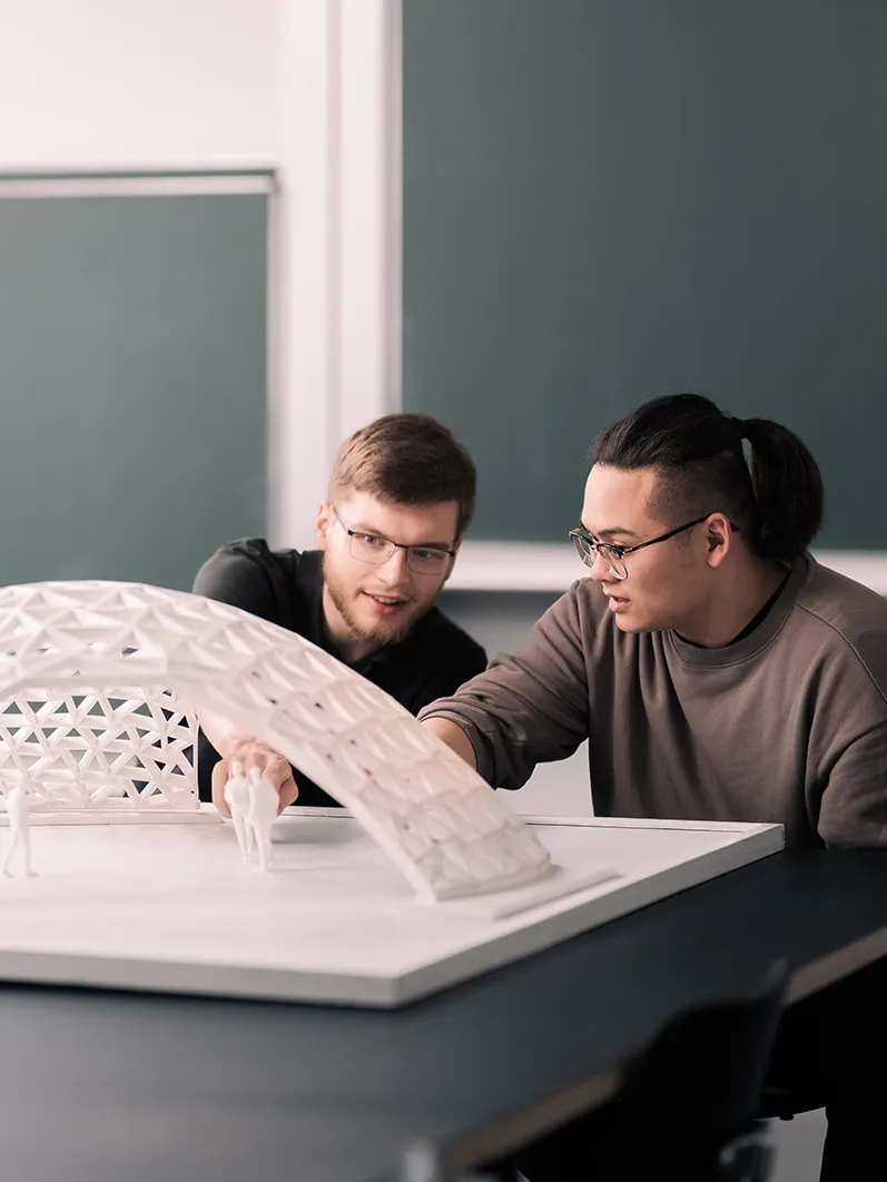 Studierende vor einem Modell in der Fakultät für Architektur und Bauwesen